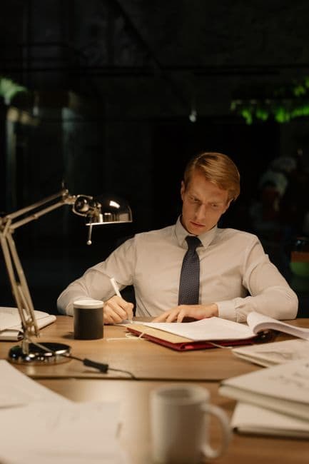 An analyst reading under a desk lamp